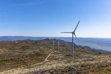 Wall Mural - Sustainability theme, view at the top at the Caramulo mountains, amazing view with wind turbines or windmills on top at the mountains, nature and typical fields with vegetation and road, Portugal