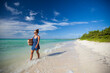 © Cavan Images - A young woman  walks the shoreline of a beach in Cayo Coco, Cuba.