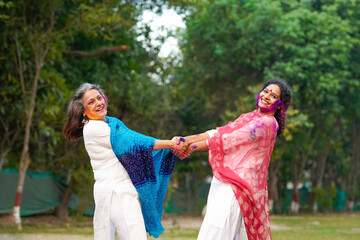 Wall Mural - Two Indian woman playing fugadi and celebrate holi festival. fugadi is culture game of hinduism.