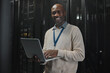 © Kirsten D/peopleimages.com - Server, laptop and portrait of black man or technician for data center, system update or cybersecurity code. Engineer or programmer person in information technology happy with ethernet and wifi power