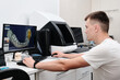 Dental technician working with a computer in a laboratory. 3D modeling of the crown in the dental lab