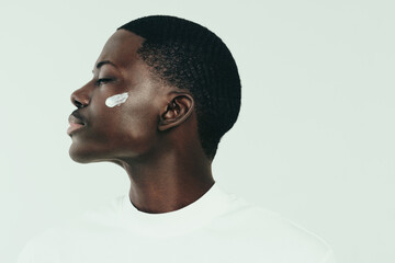 Wall Mural - Black man taking care of his melanin skin with a beauty cream