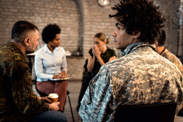 Wall Mural - Group of diverse veterans talking during PTSD support group.