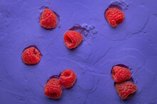 Raspberries On A Purple Decorative Background. Ripe Berry On A Background Of Powder.
