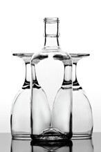 Close-up Of An Empty Glass Of Bottle In Front Of Two Upside Down Glasses