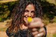 © Sheila - portrait of young woman showing a yellow daisy to camera. Springtime. Selective focus