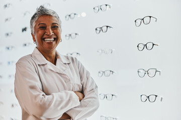 Sticker - Portrait, woman and smile of optician with arms crossed in shop or store for glasses, eyewear or spectacles. Ophthalmology, vision and laughing, proud and confident senior female medical optometrist.