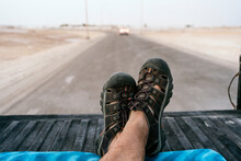Crop Legs Of Traveler Sitting On Pickup Truck During Road Trip