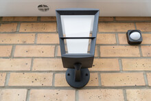Newly installed multi-colour outdoor smart light seen together with a wireless PIR detector.