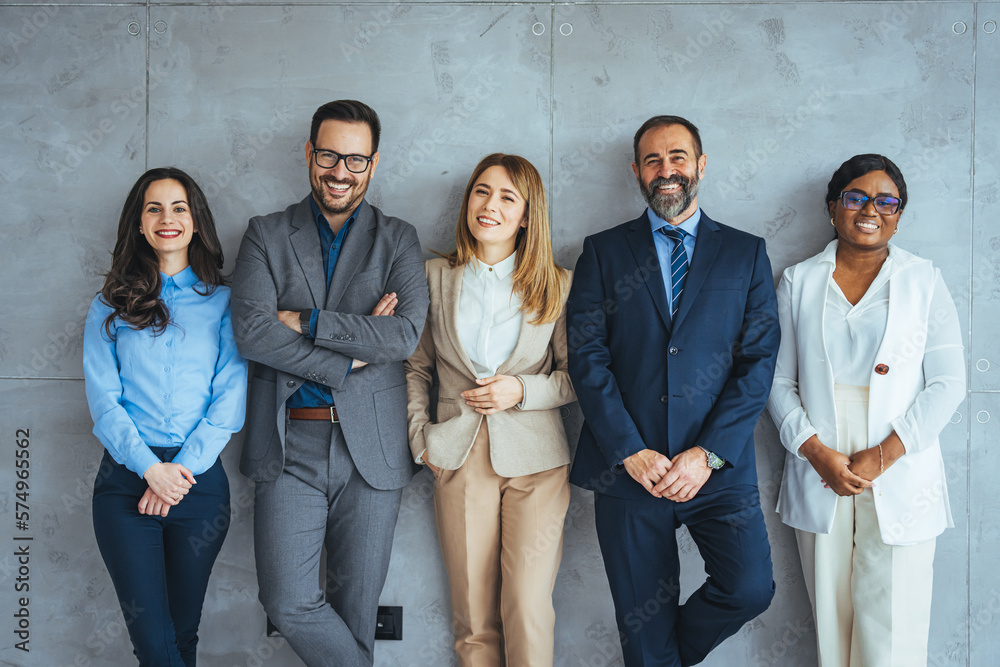 Studio portrait of a group of businesspeople posing against a gray ...