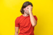 Caucasian handsome man isolated on yellow background with headache