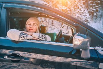 Christmas, holidays and celebration.Woman Giving Gifts. Female is holding presents and delivering them on her car to Home. Holidays concept. Driving car in Christmas Eve. People In A Snow-Covered Fore