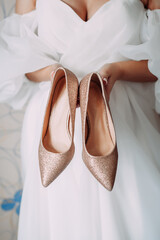 Wall Mural - Silver and gold shoes in the hands of the bride 4458.