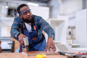 Wall Mural - In work place carpenter man concentrate working using pneumatic nail gun drive nail to the wood