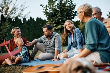 Wall Mural - Happy extended family enjoys in conversation while relaxing in backyard.