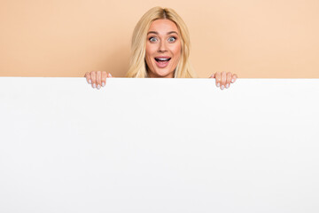 Poster - Photo of excited impressed woman holding white gig huge placard empty space isolated beige color background