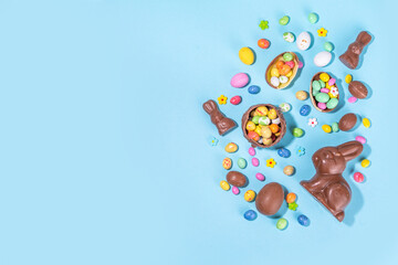 Wall Mural - Easter chocolate egg and bunny background. High-colored flat lay with chocolate bunny and rabbits, colorful chocolate eggs. Preparation for Easter, greeting card, Easter sale, top view copy space