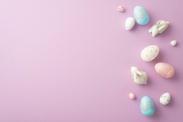 Wall Mural - Easter concept. Top view photo of colorful pink white blue eggs and ceramic easter bunnies on isolated pastel violet background with copyspace