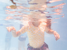 Underwater Image Of Girl Coming Up To Breath Air In Backyard Pool While Palying