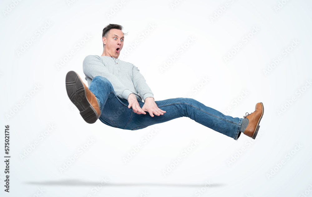Funny man in casual clothes makes a jump over a gymnastic obstacle, isolated on a light blue background