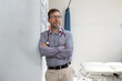© Austockphoto - Male doctor with stethoscope around his neck standing while leaning on the wall in the clinic