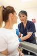 © Austockphoto - Female patient getting an injection on the arm by a female healthcare practitioner in a clinic