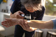 © Austockphoto - Female healthcare worker using a dermatoscope to check female patient's skin on the arms