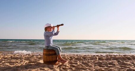 Wall Mural - Kid looking through spyglass. Summer vacation and travel concept. Slow motion