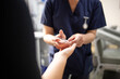 © Austockphoto - Health worker getting a blood sample from a woman using a blood lancet in the clinic