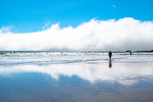 Lonely Person Silhouetted Against Ocean Coastline & Clouds At Indian Beach In Oregon