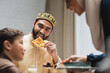 happy muslim father holding pita bread near blurred family at home.