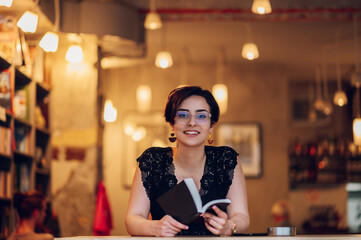 Woman reading a book while relaxing in the cafe or a bookstore