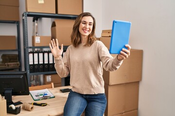 Sticker - Young woman working ecommerce doing video with tablet looking positive and happy standing and smiling with a confident smile showing teeth