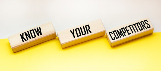 Wall Mural - on wooden blocks the text know your competitors concept of business success.