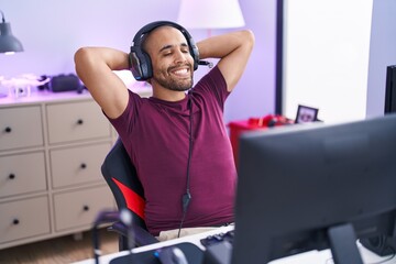 Poster - Young latin man streamer smiling confident relaxed with hands on head at gaming room