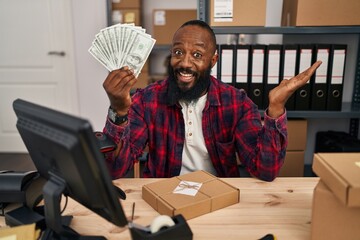 Poster - African american man working at small business ecommerce holding dollars celebrating achievement with happy smile and winner expression with raised hand