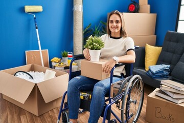 Canvas Print - Young woman sitting on wheelchair moving to a new home with a happy and cool smile on face. lucky person.