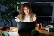 Middle age hispanic woman working using computer laptop at night looking at the camera smiling with open arms for hug. cheerful expression embracing happiness.