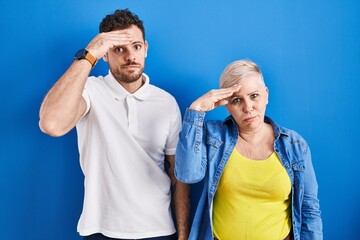 Sticker - Young brazilian mother and son standing over blue background worried and stressed about a problem with hand on forehead, nervous and anxious for crisis