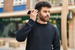 © Krakenimages.com - Young arab man listening audio message by the smartphone at street