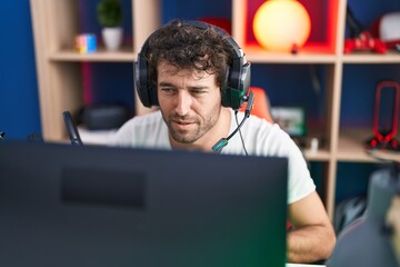 Canvas Print - Young hispanic man streamer playing video game using computer at music studio