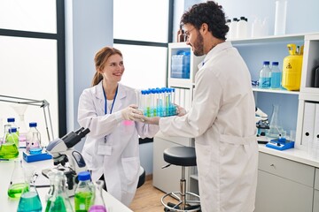 Sticker - Man and woman scientist partners holding test tubes at laboratory