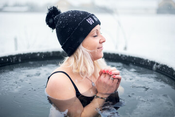 Girl is hardening by cold water during snowing