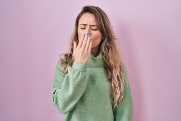 Sticker - Young caucasian woman standing over pink background bored yawning tired covering mouth with hand. restless and sleepiness.