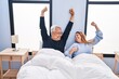 © Krakenimages.com - Middle age man and woman couple stretching arms lying on bed at bedroom