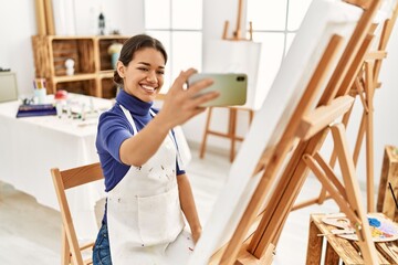 Sticker - Young latin woman smiling confident make selfie by the smartphone at art studio