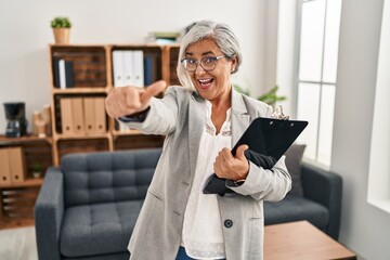 Poster - Middle age woman with grey hair at consultation office approving doing positive gesture with hand, thumbs up smiling and happy for success. winner gesture.