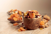 Dried Fruits And Nuts On A Beige Ceramic Table.