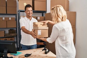 Wall Mural - Middle age man and woman business partners holding packages at storehouse