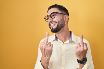 Poster - Hispanic young man wearing business clothes and glasses showing middle finger doing fuck you bad expression, provocation and rude attitude. screaming excited